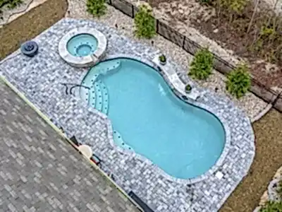 Lux Project 14 custom oasis pool with integrated spa, surrounded by waterfalls and a fireplace