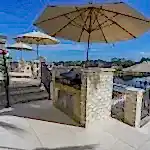 Lux Project 10 custom outdoor kitchen with umbrella beside pool