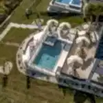 Lux Project 10 featuring a custom rectangular pool and spa with a waterfall feature, accompanied by a stylish custom fireplace