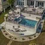 Lux Project 10 featuring a custom rectangular pool and spa with a waterfall feature, accompanied by a stylish custom fireplace